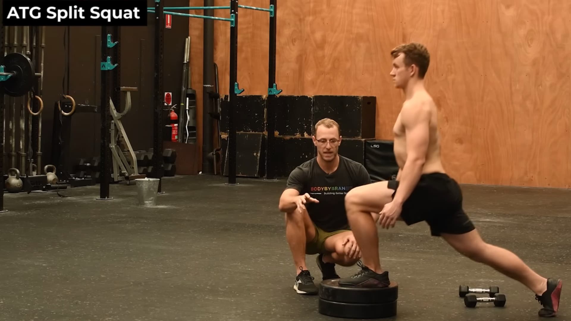 man on the elevated plates, showcasing the vertical torso and full knee flexion required for the movement