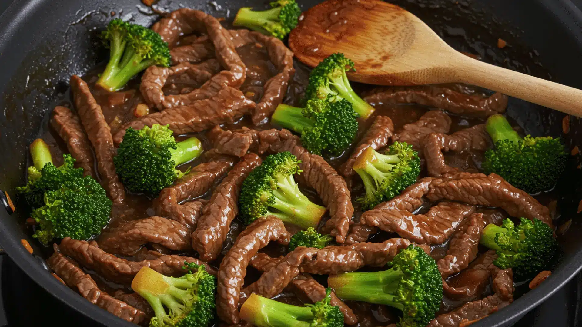 a close-up, overhead shot shows a black skillet filled with beef and broccoli stir-fry