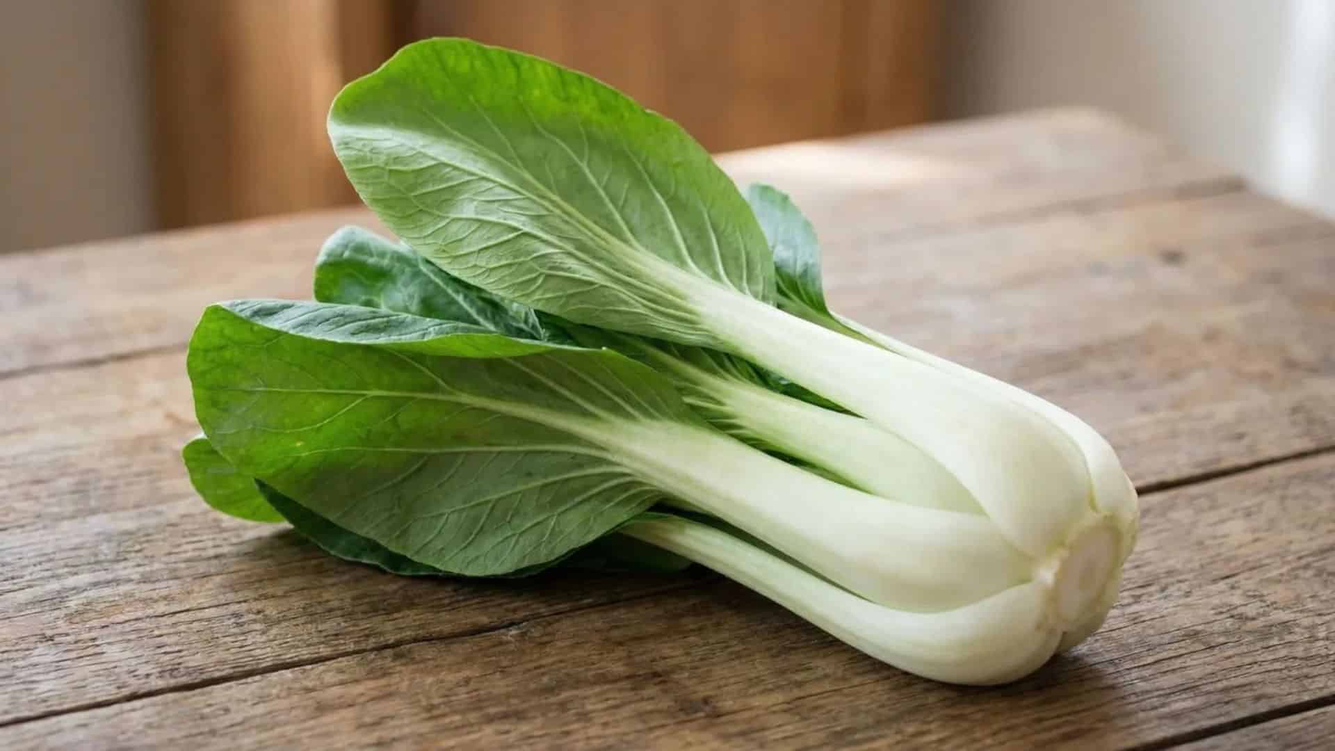 fresh whole raw bok choy resting on a rustic wooden table in soft natural light with a simple background
