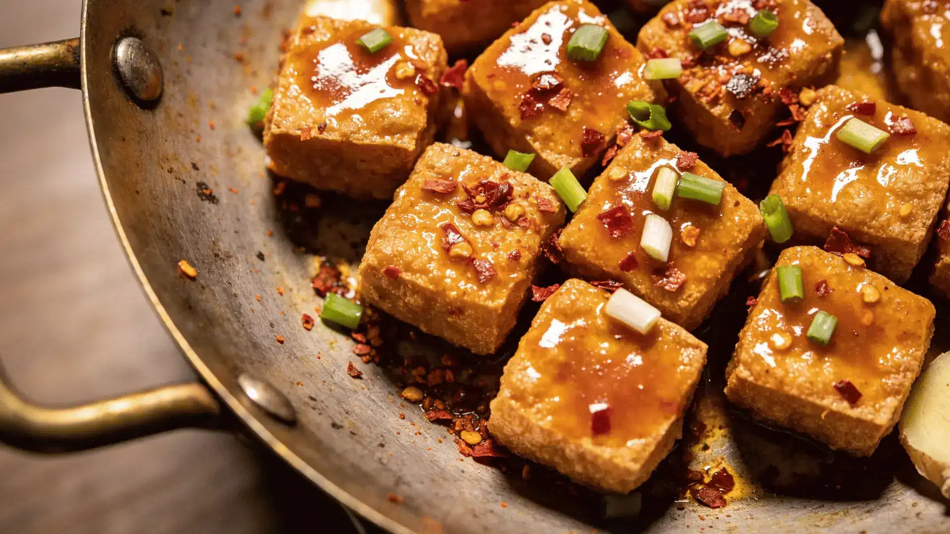 tofu pieces are cut into bite-sized rectangles and are coated in the sauce, which appears to contain chili flakes
