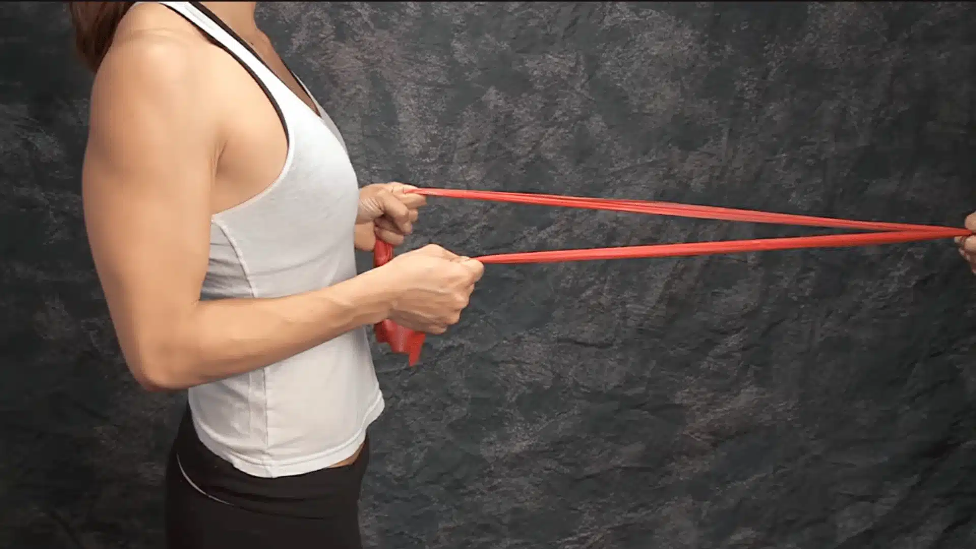 therapist demonstrates band tension while guiding proper hand and arm position