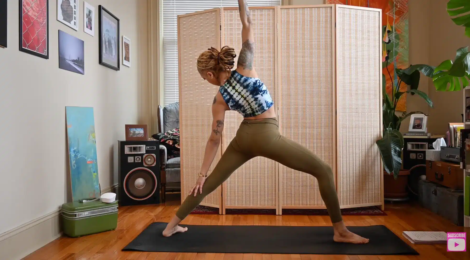 woman holding reverse warrior yoga pose indoors with raised arm extended upward and gaze turned downward for comfort