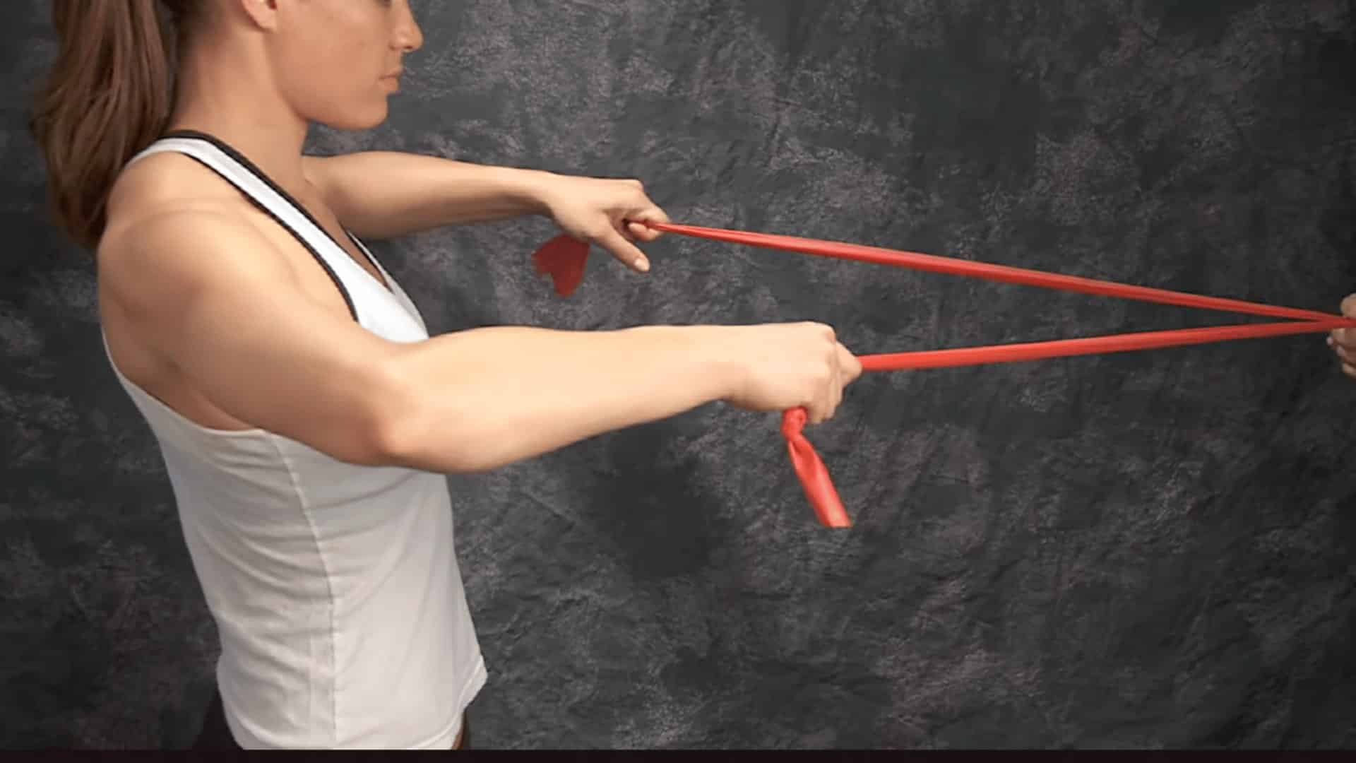 woman performs resistance band pull with arms extended to strengthen shoulders