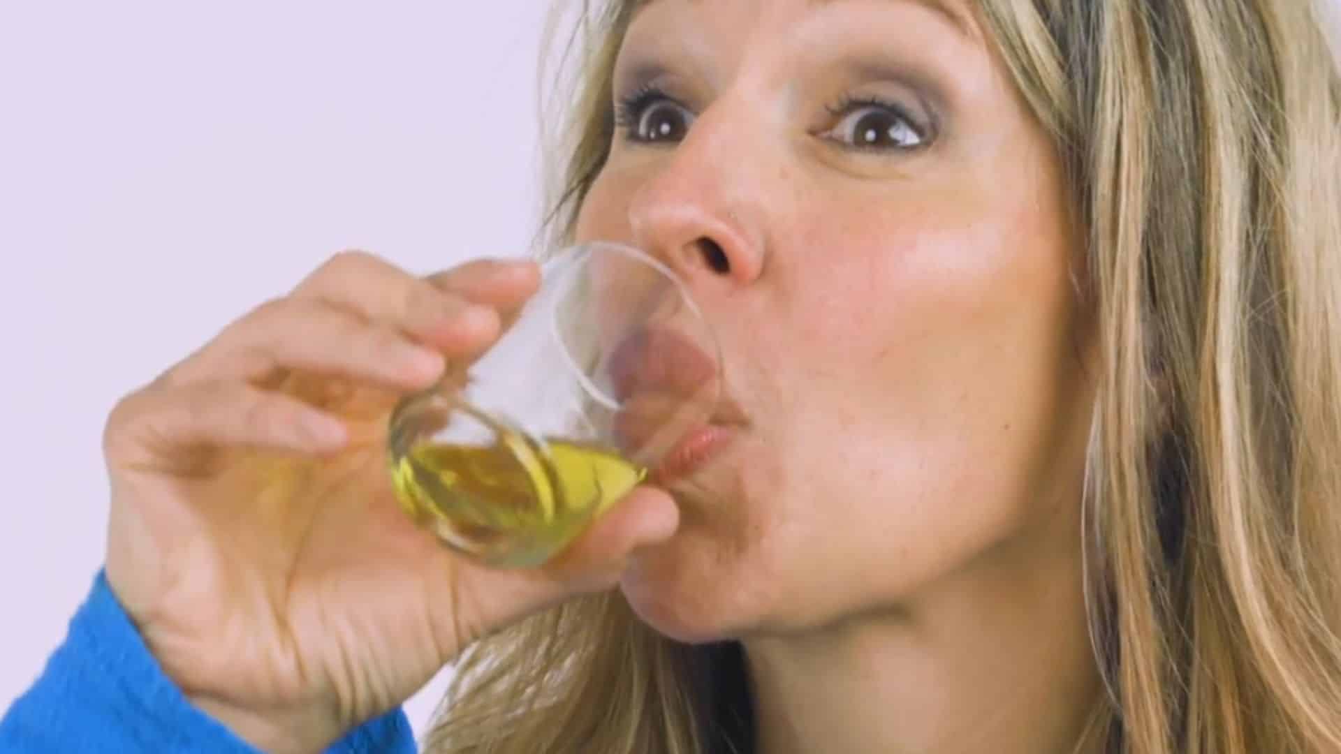 _a person gently swishing oil around their mouth and between teeth during a morning oil pulling routine