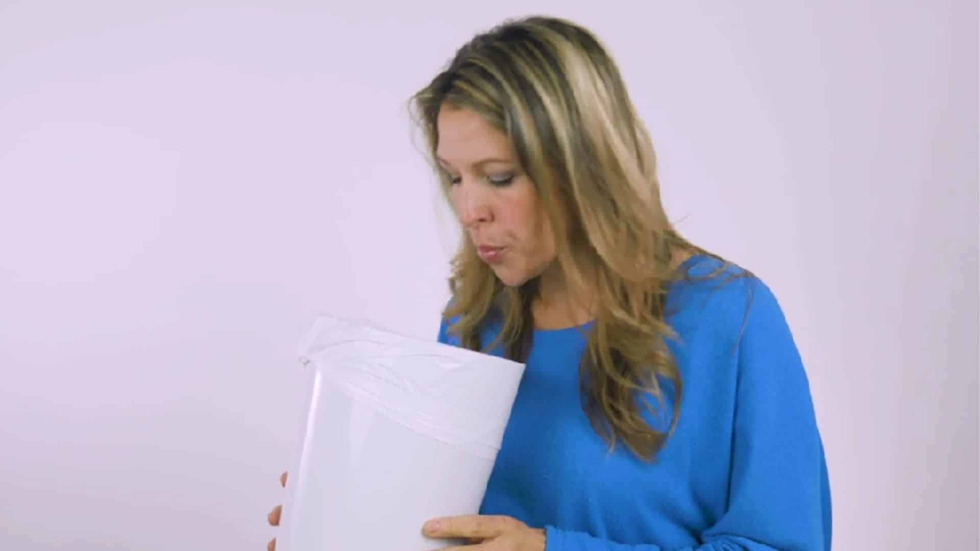 a person spitting used oil into a trash bin after oil pulling followed by rinsing the mouth with warm water (1)