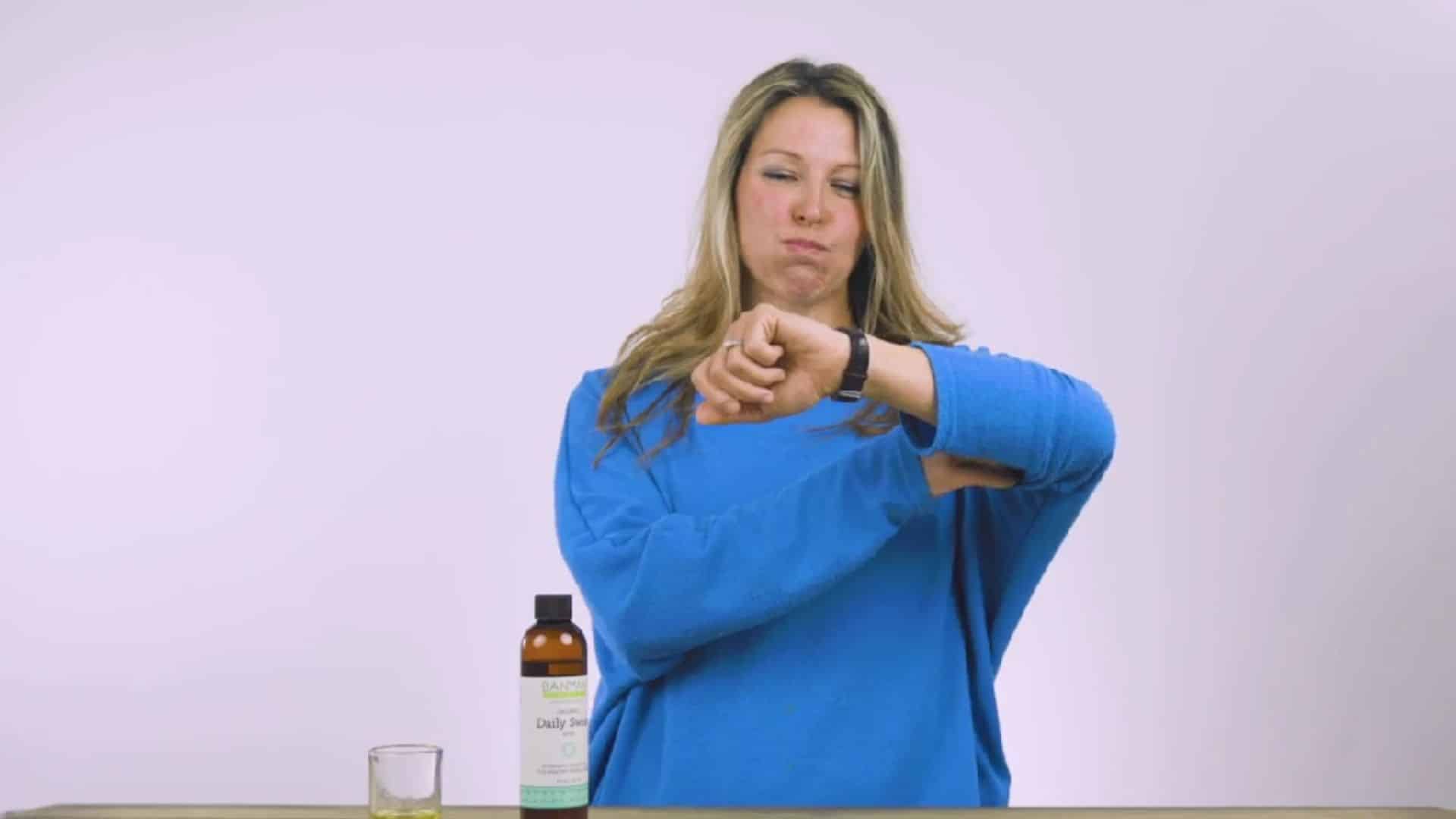 a timer set to fifteen minutes placed beside a glass of oil to track the duration of an oil pulling session