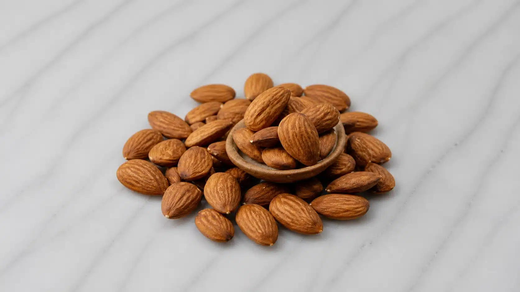 aw almonds in a bowl on marble surface with soft lighting