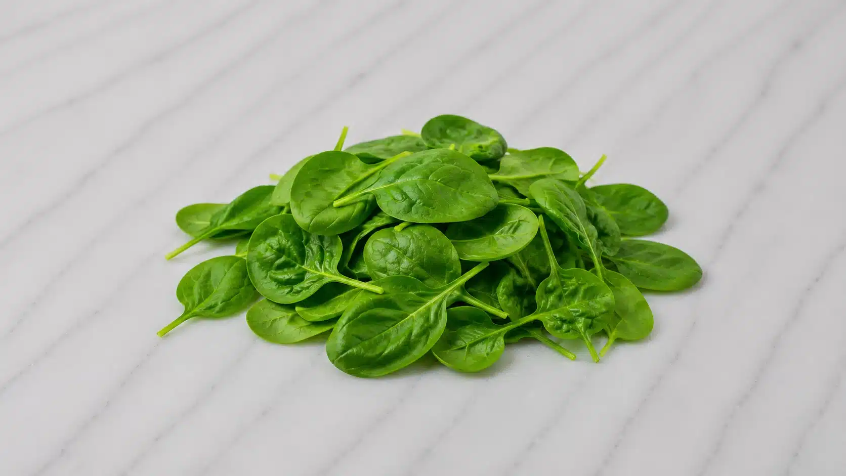 fresh spinach leaves on marble surface with soft natural kitchen lighting