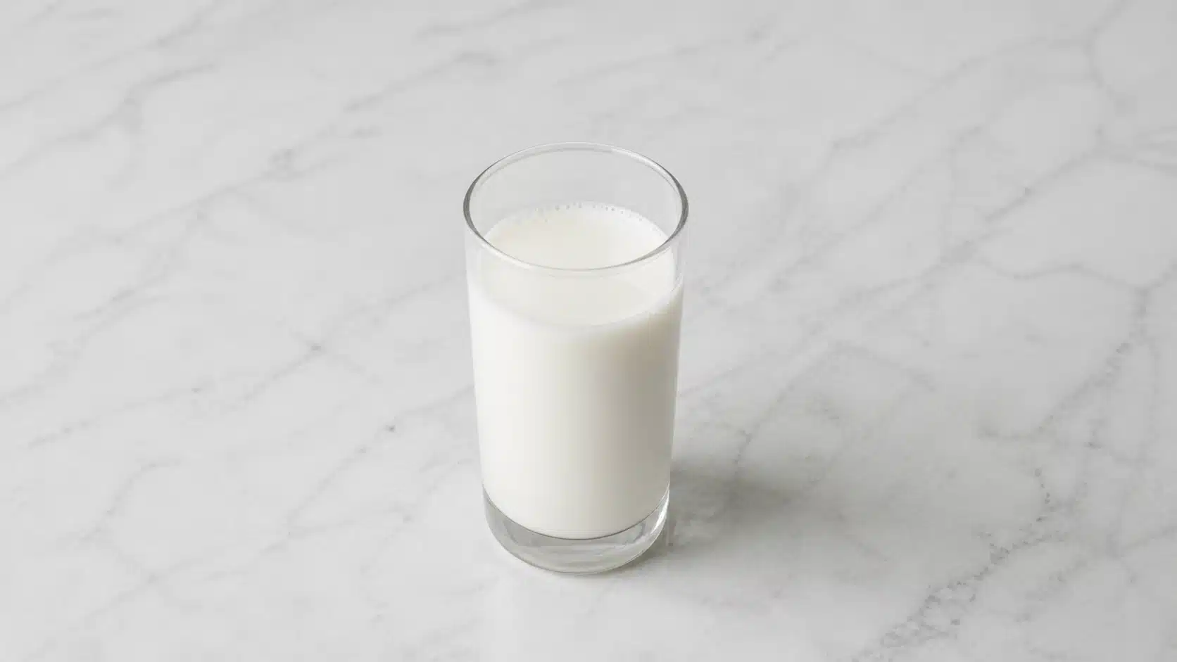 glass of whole milk on marble surface in soft natural light