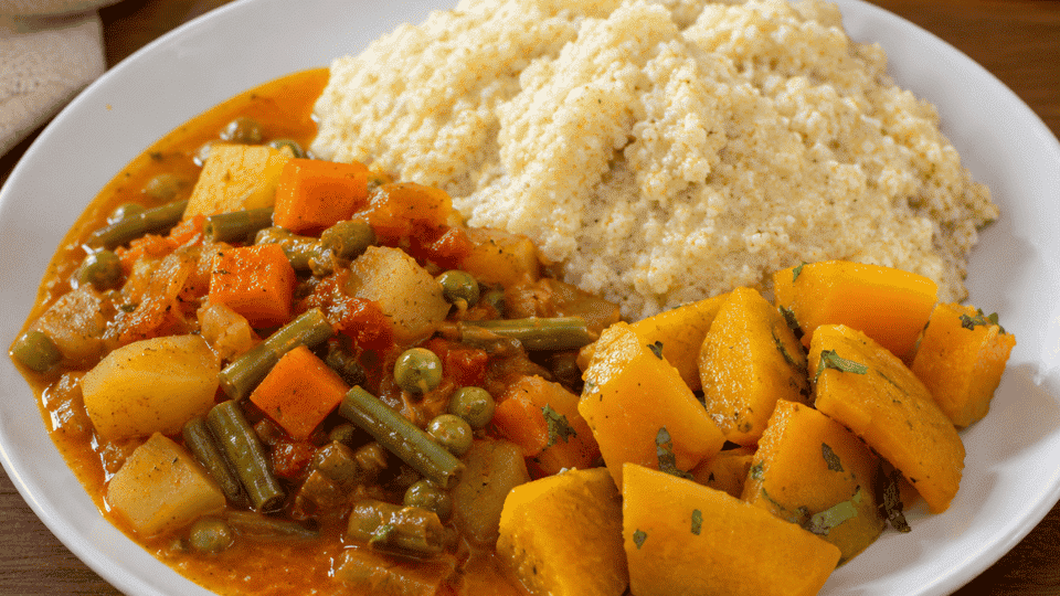 light millet porridge, mild vegetable stew, and cooked squash served together on a white plate