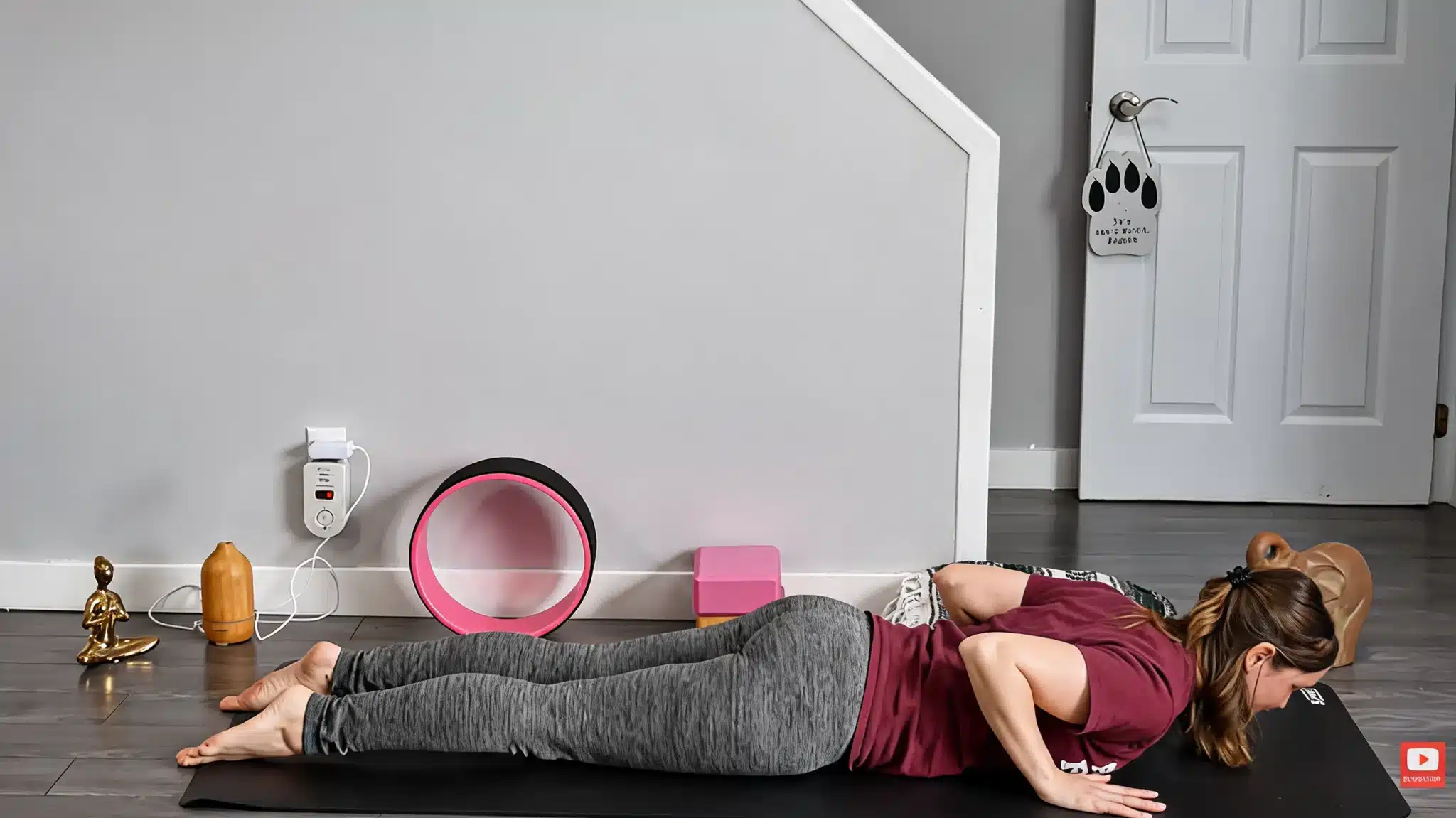woman lying face down on yoga mat with hands under shoulders preparing for baby cobra pose indoors