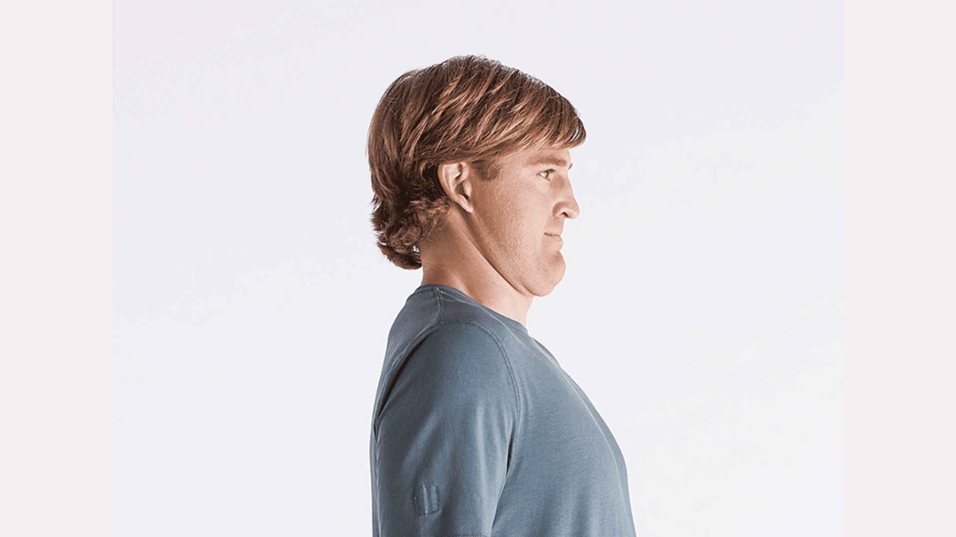 man demonstrating a chin tuck exercise in side view with neck aligned and shoulders relaxed