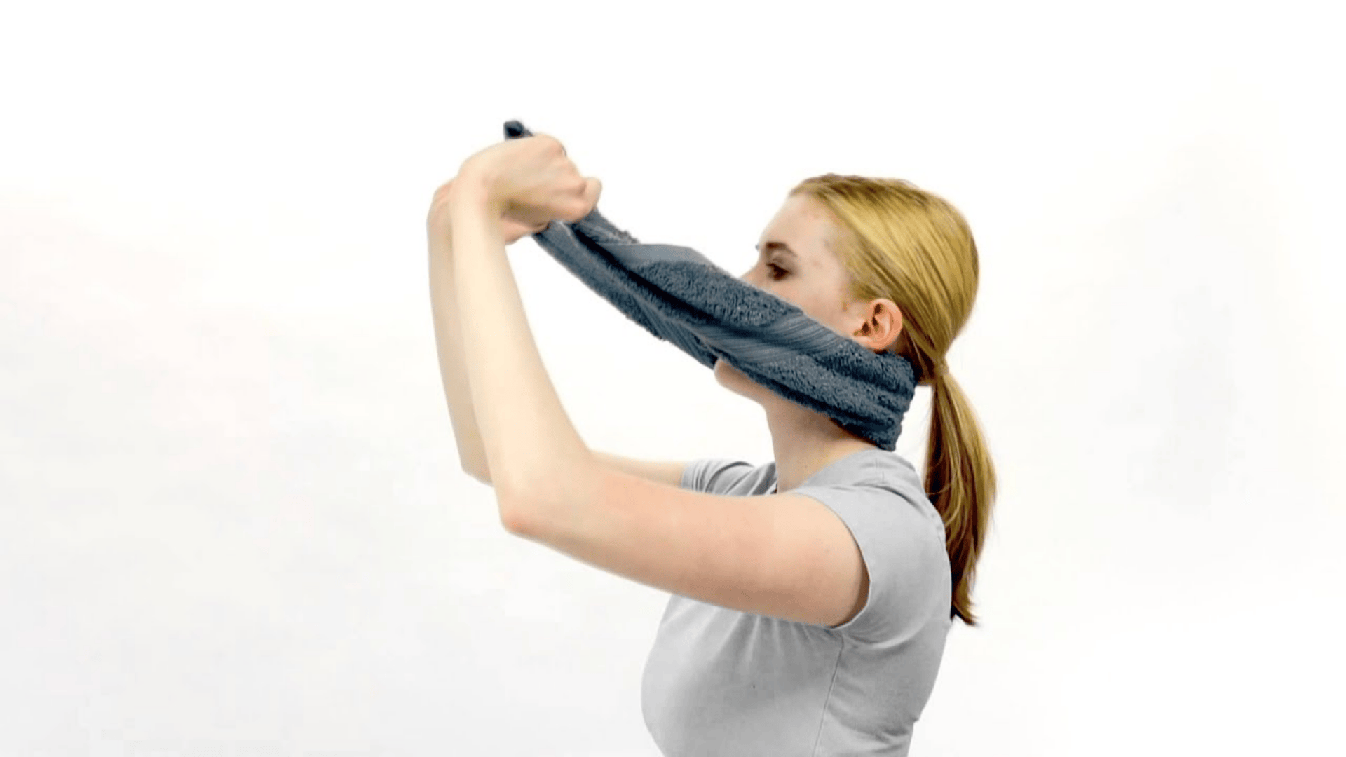 person using a towel behind the neck for a gentle supported seated neck stretch and posture relief