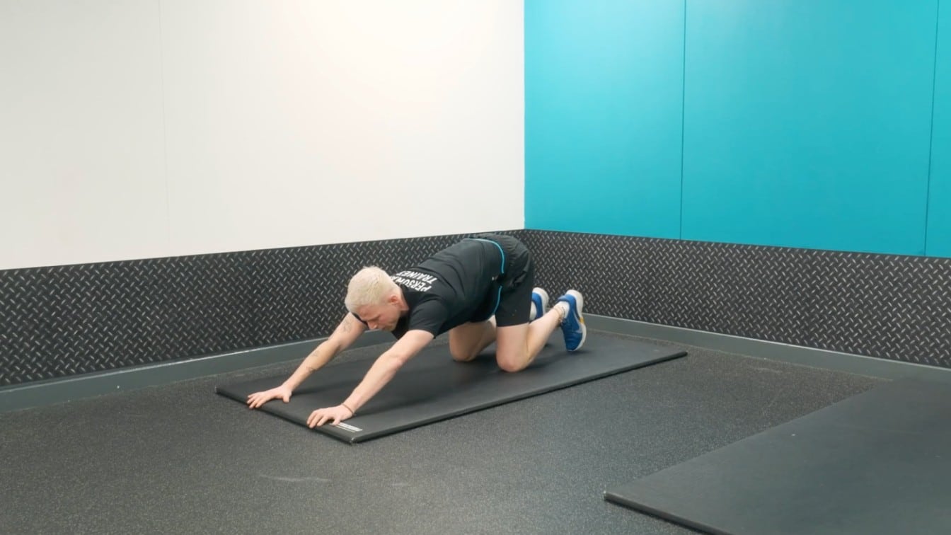 instructor moves deeper into the stretch with hips lifted