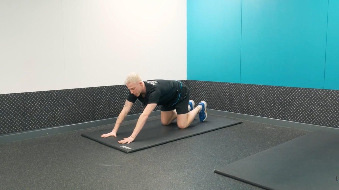 instructor reaches the arms forward and lowers the chest
