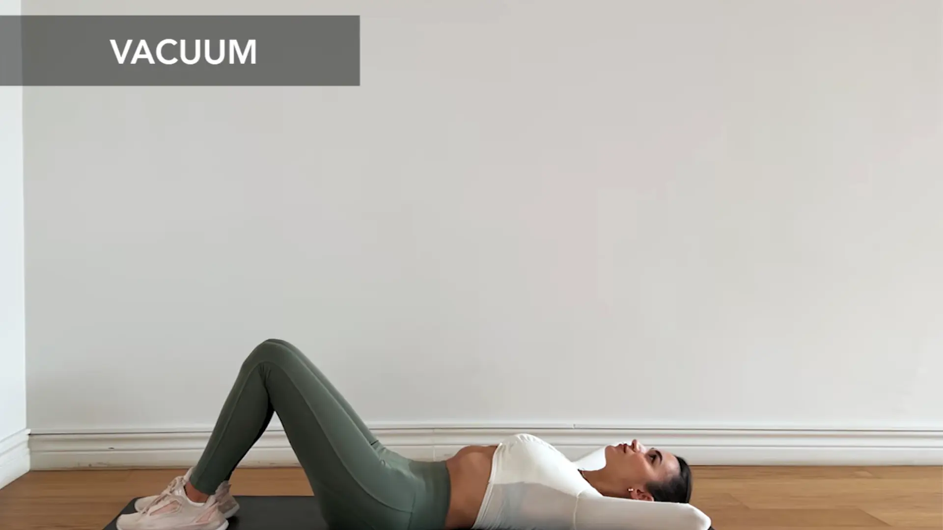 person holding stomach vacuum contraction on yoga mat with calm breathing and control