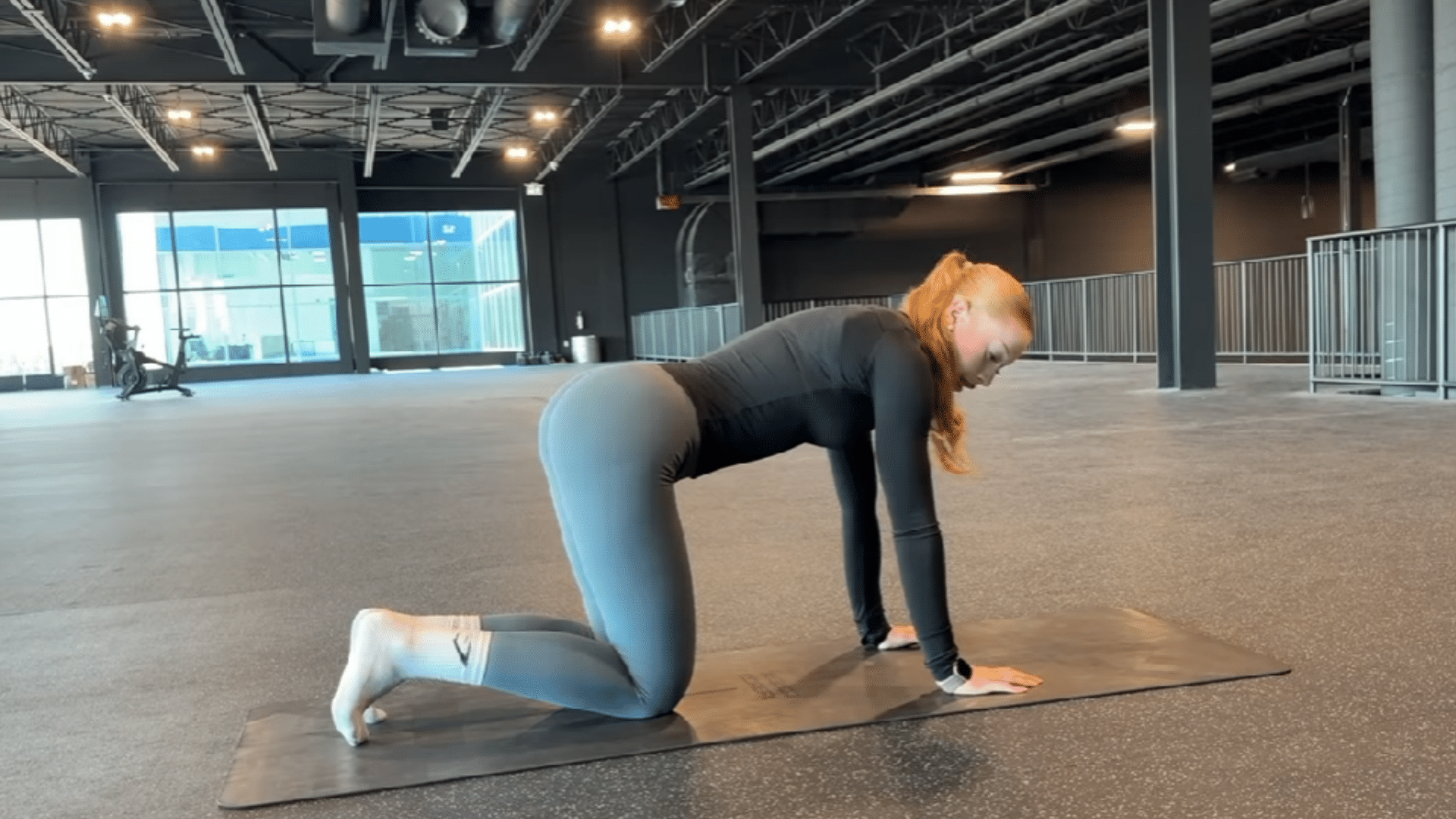 Person lowering a bent knee slowly while performing a donkey kick