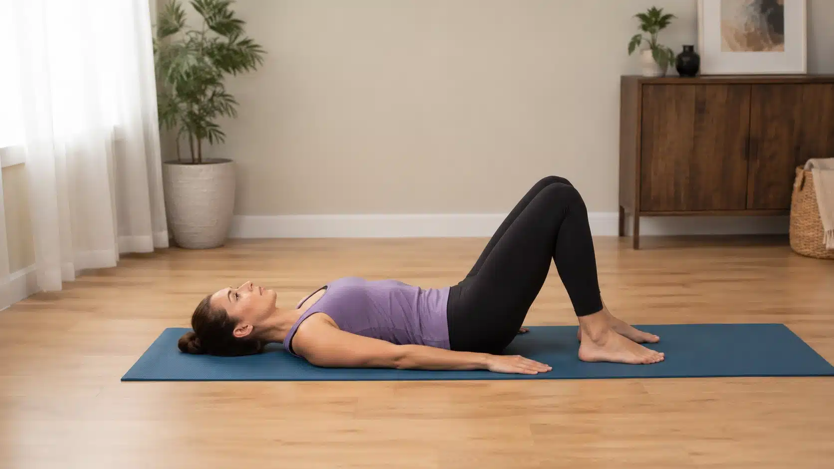 woman doing pelvic tilts on a yoga mat to support gentle lower core strength and posture